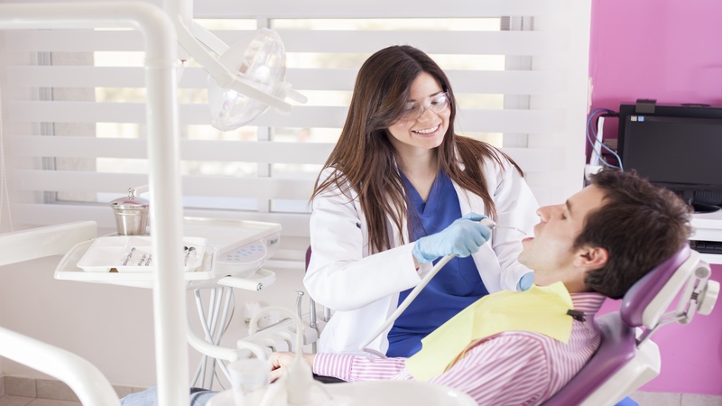 18271571 – happy dentist bringing a clean smile from a patient