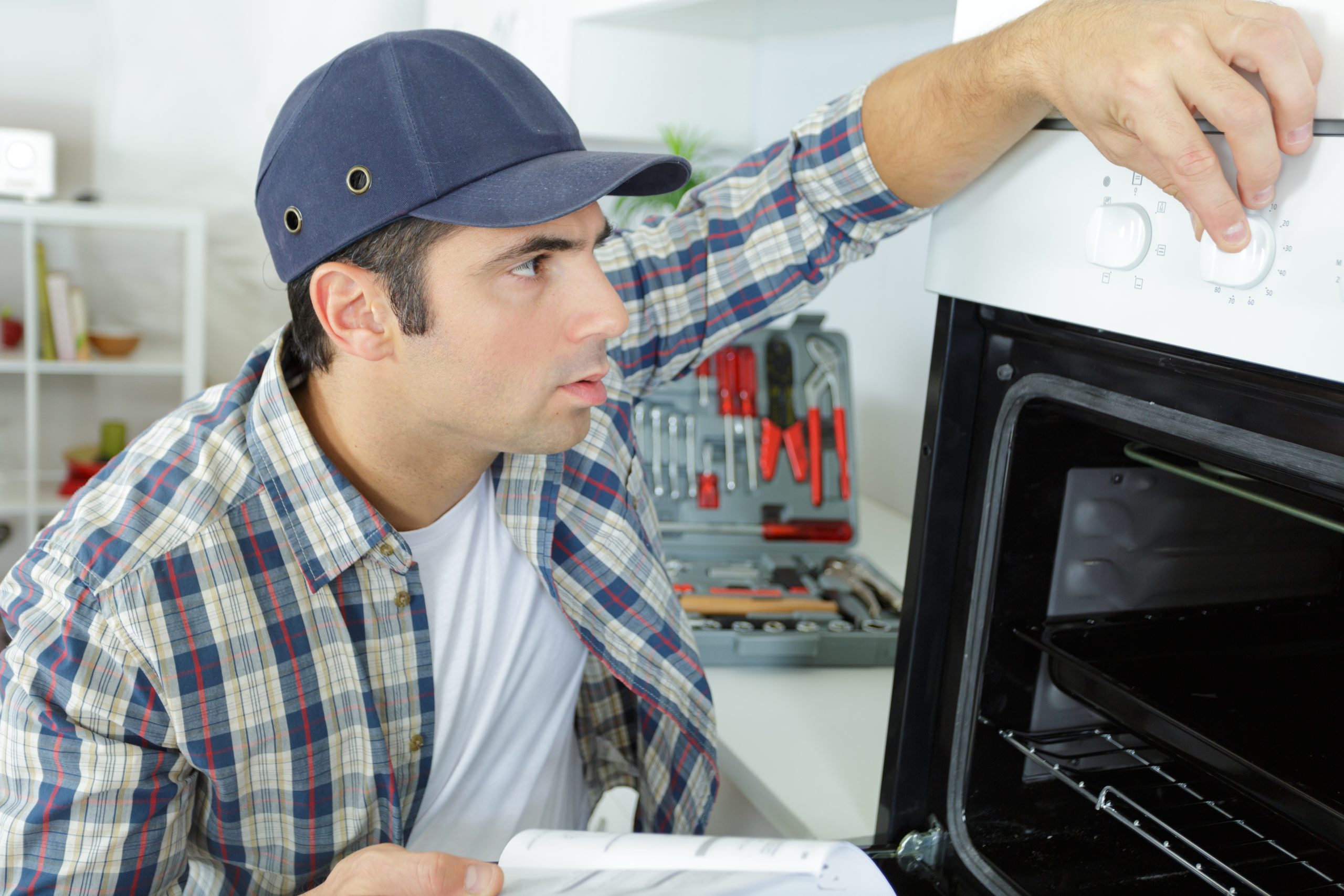 young man regulating temperature of a broken oven